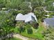 Scenic aerial view of home with solar panels, near a lake, surrounded by trees and lush landscaping at 4443 Robin Hood W Trl, Sarasota, FL 34232