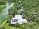 Stunning aerial view of the home with solar panels, lush landscaping, and serene lake frontage at 4443 Robin Hood W Trl, Sarasota, FL 34232