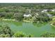 Wide aerial view of the home with lush greenery and waterfront views at 4443 Robin Hood W Trl, Sarasota, FL 34232