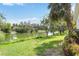 Scenic backyard view featuring a serene lake, lush greenery, and mature trees creating a private oasis at 4443 Robin Hood W Trl, Sarasota, FL 34232