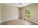 Bedroom with neutral walls, fan, light wood-look floors, and a window view at 4443 Robin Hood W Trl, Sarasota, FL 34232