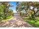 Charming home with a brick driveway, mature trees, and lush landscaping at 4443 Robin Hood W Trl, Sarasota, FL 34232