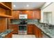 Charming kitchen with wood cabinets, stainless steel appliances, and marble countertops at 4443 Robin Hood W Trl, Sarasota, FL 34232
