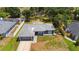 Aerial view of a gray house with an attached garage, expansive driveway and well-maintained green lawn at 4664 Hegira St, North Port, FL 34286