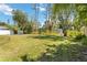 The expansive backyard has mature trees, lush vegetation, and a storage shed at 4664 Hegira St, North Port, FL 34286