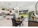 Bright dining area featuring a glass table, four chairs, and sliding glass doors offering a view of the backyard at 4664 Hegira St, North Port, FL 34286