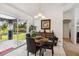 Cozy dining area with a glass table, four chairs, and sliding glass doors leading to a screened patio at 4664 Hegira St, North Port, FL 34286