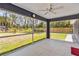 Spacious screened porch with ceiling fan, offering view of fenced backyard with mature trees at 4664 Hegira St, North Port, FL 34286