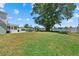 Beautiful waterfront backyard featuring a large shade tree, patio with furniture, and stunning lake views at 4708 26Th W Ave, Bradenton, FL 34209
