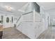 Entry foyer with a decorative glass front door, wood look floors, staircase with white railings, and coat closet at 4708 26Th W Ave, Bradenton, FL 34209