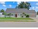 Charming single story home with a red door, a well manicured lawn and a paved driveway in a quiet neighborhood at 4708 26Th W Ave, Bradenton, FL 34209