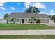 Charming single-story home featuring a well-manicured lawn, palm trees, and a cozy front porch at 4708 26Th W Ave, Bradenton, FL 34209