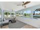 Bright sunroom with multiple windows overlooking the pool and lake, furnished with a gray sectional and rug at 4708 26Th W Ave, Bradenton, FL 34209