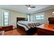 Bedroom with a ceiling fan, two windows, hardwood floors, and matching furniture at 4873 Huntleigh Dr, Sarasota, FL 34233