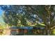 Single story home with mature trees and green landscaping at 4873 Huntleigh Dr, Sarasota, FL 34233