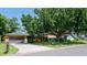 Single Gathering home with brown two car garage, yellow facade and mature landscaping at 4873 Huntleigh Dr, Sarasota, FL 34233