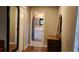 Hallway featuring wood floors, decorative mirror, and bathroom view with modern tile floors at 4873 Huntleigh Dr, Sarasota, FL 34233