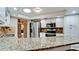 Open kitchen design with stainless steel appliances, granite countertops, and stylish backsplash at 4873 Huntleigh Dr, Sarasota, FL 34233