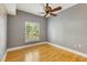 Bright bedroom featuring hardwood floors, a ceiling fan, and a large window with shutters at 5168 Northridge Rd # 106, Sarasota, FL 34238