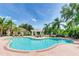 Resort-style community pool surrounded by lush landscaping, lounge chairs, and BBQ grills at 5168 Northridge Rd # 106, Sarasota, FL 34238