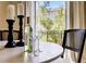 A well-lit dining table set with wine glasses, candles and view to outdoor foliage through french doors at 525 N Orange Ave # 202, Sarasota, FL 34236