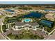 Aerial view of community amenities, including a pool, clubhouse, tennis courts, and serene lakes at 5770 Long Shore Loop, Sarasota, FL 34238