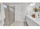 Bathroom featuring a glass shower, white cabinets, quartz countertops, and modern lighting fixtures at 5770 Long Shore Loop, Sarasota, FL 34238