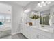 Bathroom featuring a double vanity, white cabinets, quartz countertops, and modern lighting fixtures at 5770 Long Shore Loop, Sarasota, FL 34238