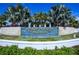 Community entrance signage featuring lush landscaping, a water feature, and stone masonry at 5770 Long Shore Loop, Sarasota, FL 34238