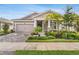 Inviting home with stone accents, beautiful landscaping, a two-car garage, and a cozy front porch at 5770 Long Shore Loop, Sarasota, FL 34238