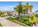 Charming single-story home with lush landscaping, including palm trees, and a paved driveway at 5770 Long Shore Loop, Sarasota, FL 34238