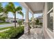 Charming covered front porch with stone columns and a cozy chair, perfect for relaxing outdoors at 5770 Long Shore Loop, Sarasota, FL 34238
