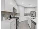 Modern kitchen featuring white cabinets, stainless steel appliances, gray subway tile backsplash and gray tile floors at 5770 Long Shore Loop, Sarasota, FL 34238