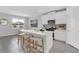 Well lit kitchen with white cabinets, a large island with barstools, stainless steel appliances, and light gray tile floors at 5770 Long Shore Loop, Sarasota, FL 34238