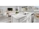 Bright kitchen island with seating, stainless steel appliances, and an open view to the living room at 5770 Long Shore Loop, Sarasota, FL 34238