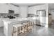 Bright kitchen features white cabinetry, stainless steel appliances, and a large island with bar seating at 5770 Long Shore Loop, Sarasota, FL 34238