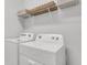 Bright laundry room featuring a modern, front-loading washer and dryer with storage shelves at 5770 Long Shore Loop, Sarasota, FL 34238