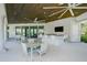 Outdoor kitchen features bar seating, a TV, and elegant patio furniture at 5770 Long Shore Loop, Sarasota, FL 34238