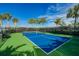 Well-maintained community pickleball court for active play, surrounded by palm trees and a secure fence at 5770 Long Shore Loop, Sarasota, FL 34238