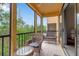 Screened balcony with wicker seating and a view of the surrounding greenery at 603 Cedars Ct, Longboat Key, FL 34228