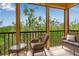 Relaxing balcony with wicker furniture overlooking a lush, green landscape at 603 Cedars Ct, Longboat Key, FL 34228