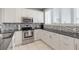 Well-lit kitchen featuring stainless steel appliances and white cabinetry with elegant backsplash at 603 Cedars Ct, Longboat Key, FL 34228