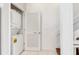 Functional laundry area featuring stacked washer and dryer for space saving convenience in white at 603 Cedars Ct, Longboat Key, FL 34228