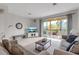 Bright living room featuring tile flooring, comfortable sofas, and balcony access at 603 Cedars Ct, Longboat Key, FL 34228