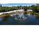 A beautiful pond with a fountain is surrounded by trees and has park benches nearby at 603 Cedars Ct, Longboat Key, FL 34228
