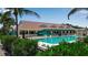 Large swimming pool and clubhouse with lush landscaping, perfect for outdoor recreation and community gatherings at 603 Cedars Ct, Longboat Key, FL 34228