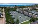 Aerial view of well-maintained tennis courts within a residential community with lush green landscaping at 603 Cedars Ct, Longboat Key, FL 34228