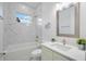 Contemporary bathroom with marble tile, a soaking tub, and a stylish vanity with a large mirror at 6146 Grandeur St, Englewood, FL 34224