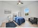 Bright bedroom features a ceiling fan, wood floors, and a cozy seating area near the window at 6146 Grandeur St, Englewood, FL 34224
