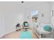 Cozy Bedroom with a white crib, accent rocking chair, and bright window providing natural light at 6146 Grandeur St, Englewood, FL 34224